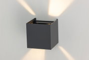 Moderne LED-Wandleuchte in Würfelform, die von oben und unten Licht abstrahlt. Perspektive: seitliche Ansicht.