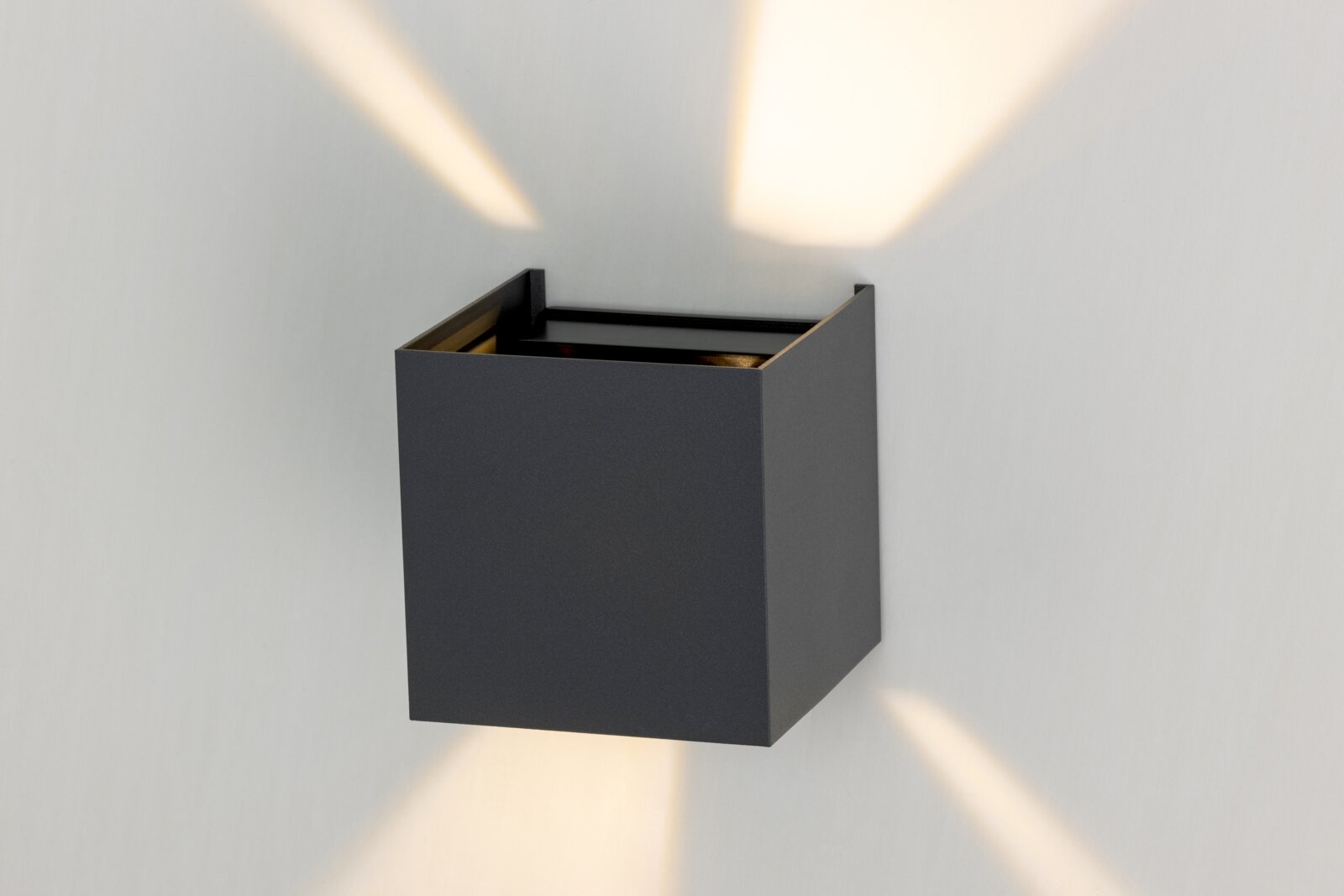 Moderne LED-wandlamp in kubusvorm, die zowel van boven als van onderen licht verspreidt. Perspectief: zijaanzicht.