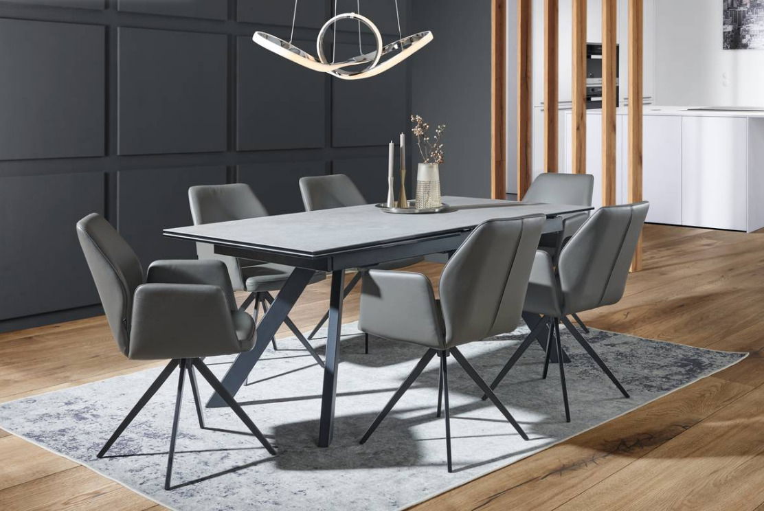 Moderner Esstisch mit grauer Tischplatte und sechs gepolsterten Stühlen in einem stilvollen Esszimmer, seitliche Perspektive.