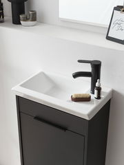 Modernes Gästebad-Set mit schwarzem Waschbeckenunterschrank und weißem Waschbecken, seitliche Perspektive