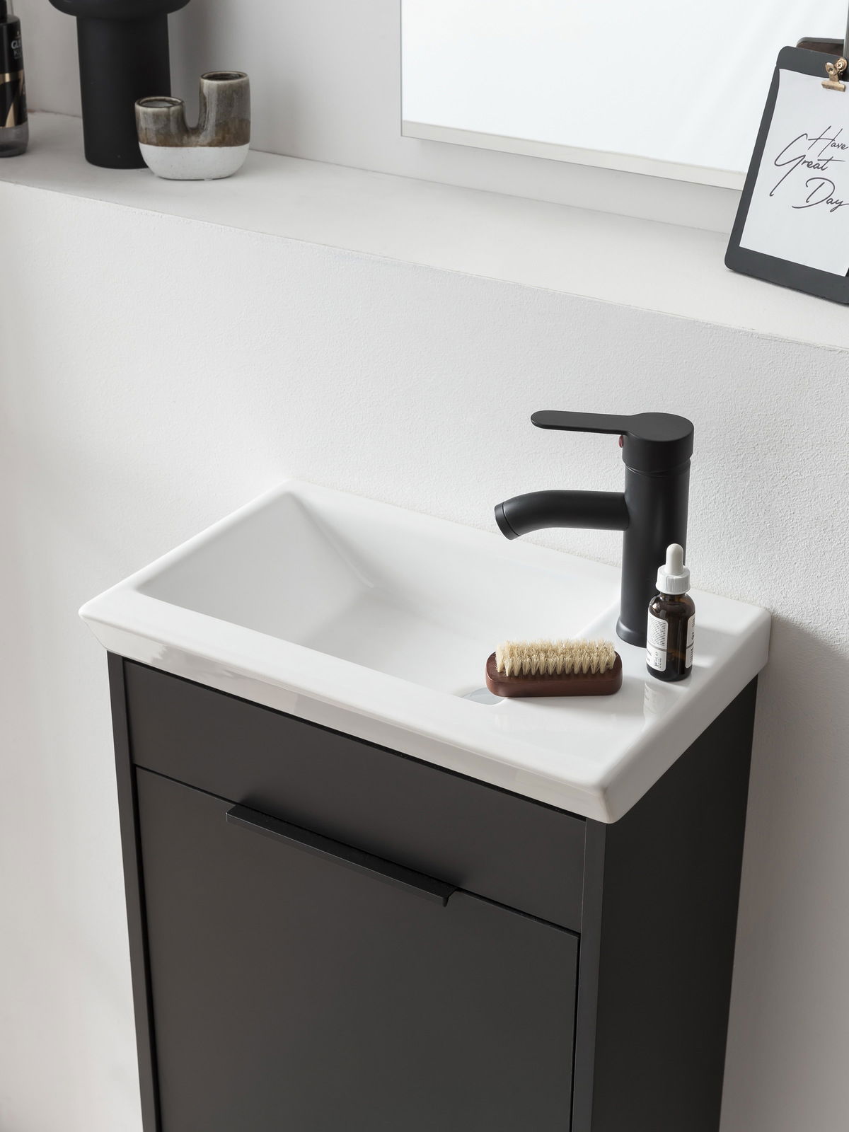 Modernes Gästebad-Set mit schwarzem Waschbeckenunterschrank und weißem Waschbecken, seitliche Perspektive