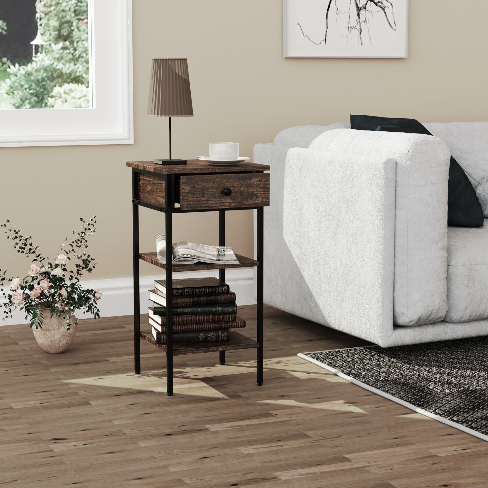 Schmaler Beistelltisch/Nachttisch im Industrial-Design mit schwarzem Metallrahmen, dunkelbrauner Holzoptik, Schublade und Ablagefächern neben einem hellen Sofa; Perspektive: frontale leicht schräge Ansicht von vorn.