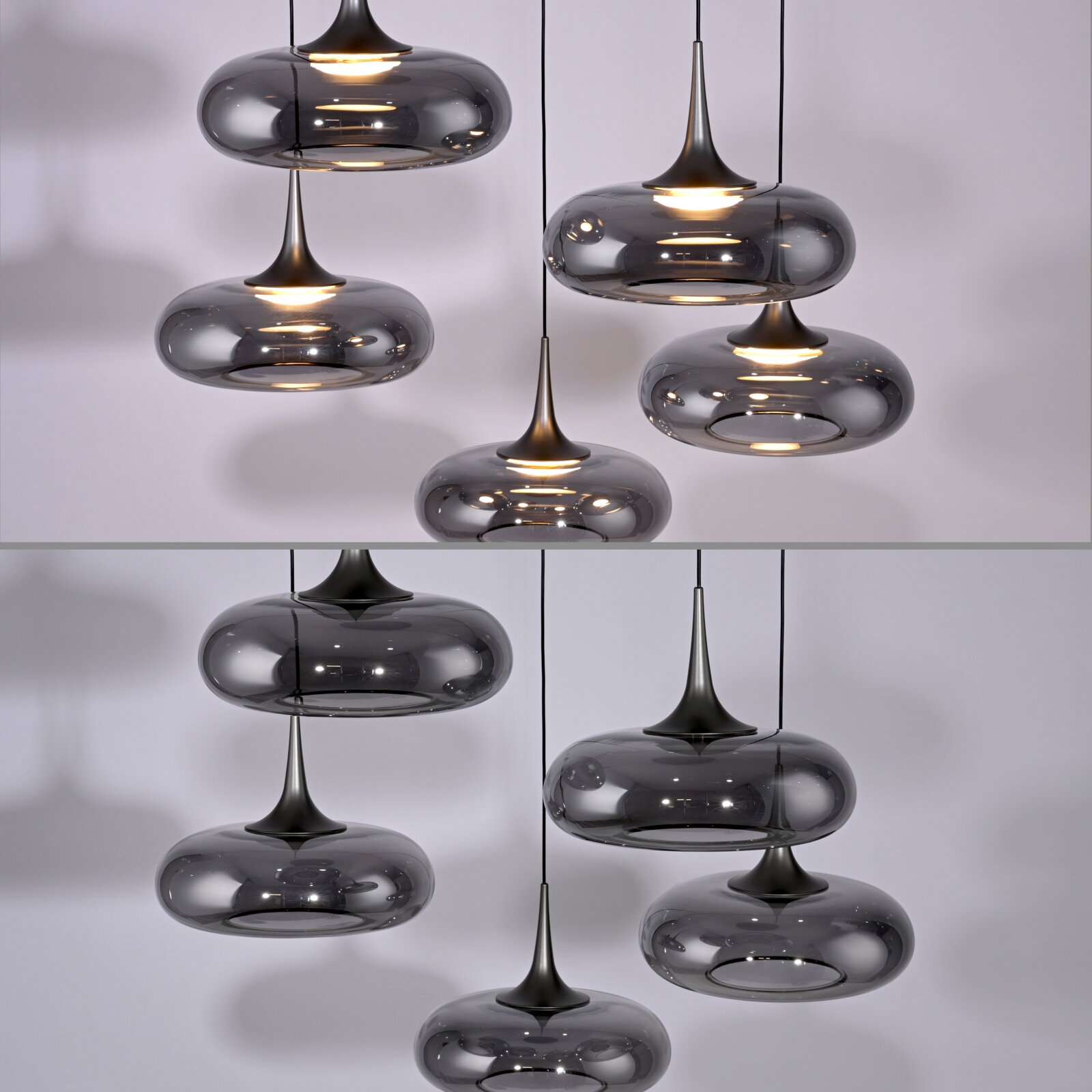 Mehrere moderne Pendelleuchten mit rauchgrauen, ovalen Glasschirmen und dunklen Metallspitzen, warm leuchtend, in leichter Untersicht vor hellem Hintergrund