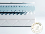 Querschnitt einer Jugendmatratze mit wellenförmiger Struktur und Qualitätssiegel von Julius Zöllner, seitlich betrachtet.