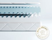 Querschnitt einer Jugendmatratze mit wellenförmiger Struktur und Qualitätssiegel von Julius Zöllner, seitlich betrachtet.