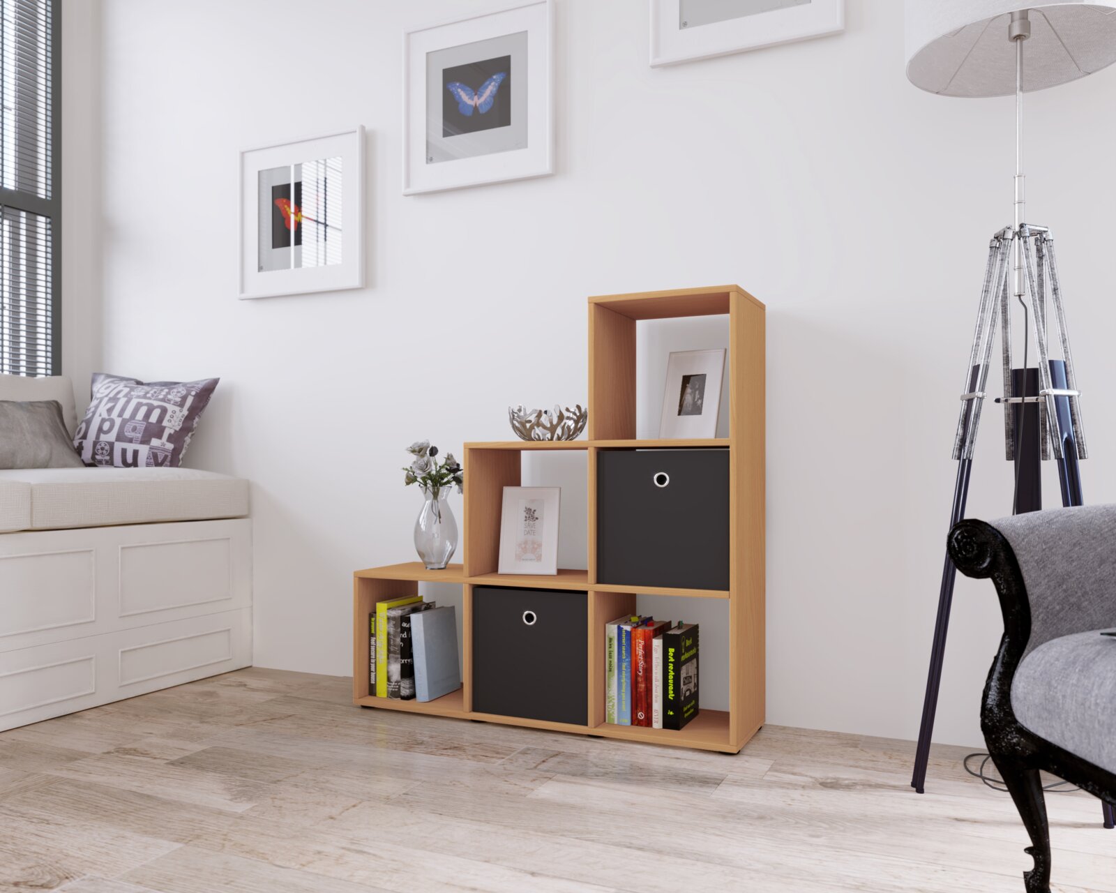 VCM Treppenregal NITAS Modernes Stufenregal in heller Holzoptik mit offenen Fächern und zwei schwarzen Boxeinsätzen, dekoriert mit Büchern, Vase und Bilderrahmen, im Wohnzimmer – frontale Ansicht mit leichter Perspektive von links.