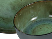 Nahaufnahme eines grünen Tellers und einer Schüssel mit glänzender Glasur, seitliche Perspektive