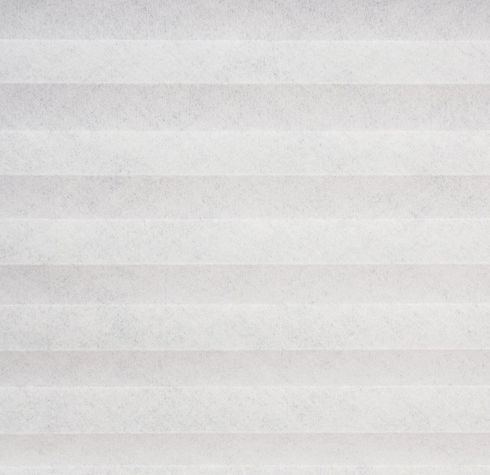 Nahaufnahme eines weißen, gefalteten Plissees in horizontaler Perspektive.