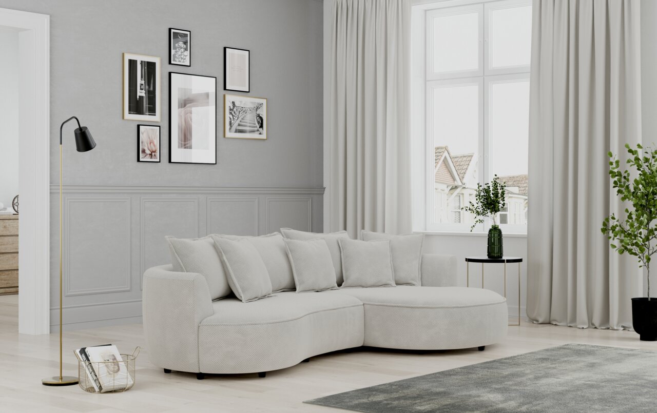 Lounge Handmade Hoekbank LEVI De moderne Ottre-hoekbank in een elegante woonkamer, gezien vanaf de zijkant, met lichte kussens en een ronde salontafel.