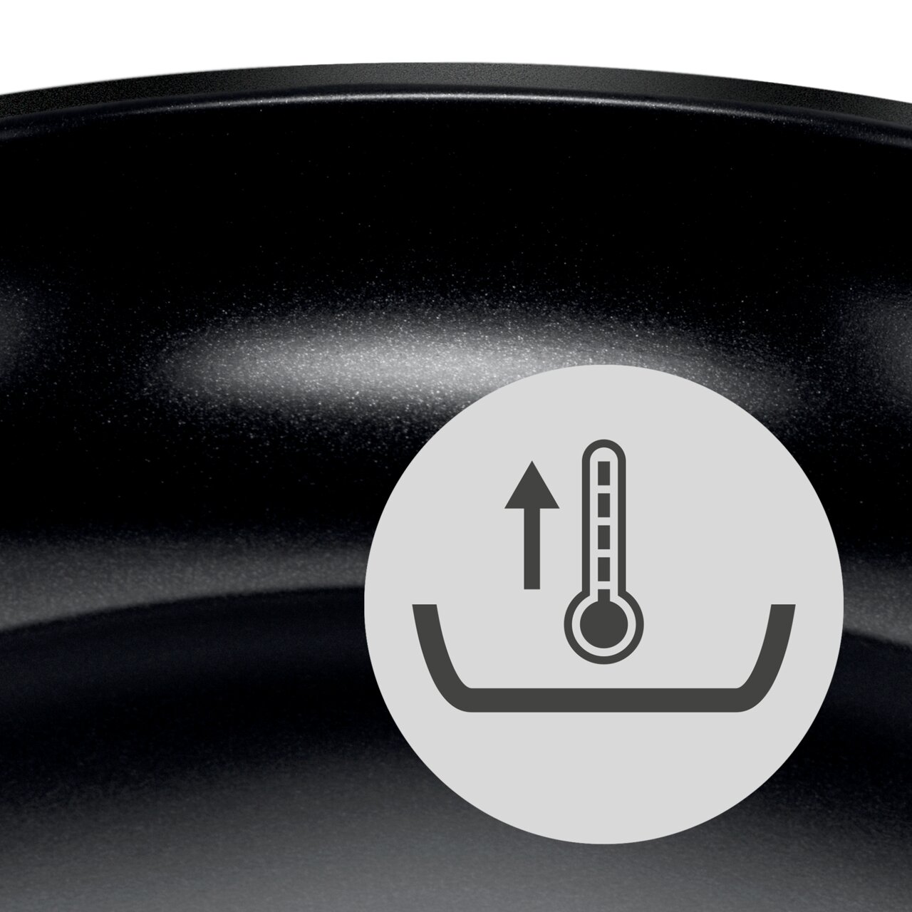 Nahaufnahme einer schwarzen Wokpfanne mit einem Symbol für Temperaturanzeige.
