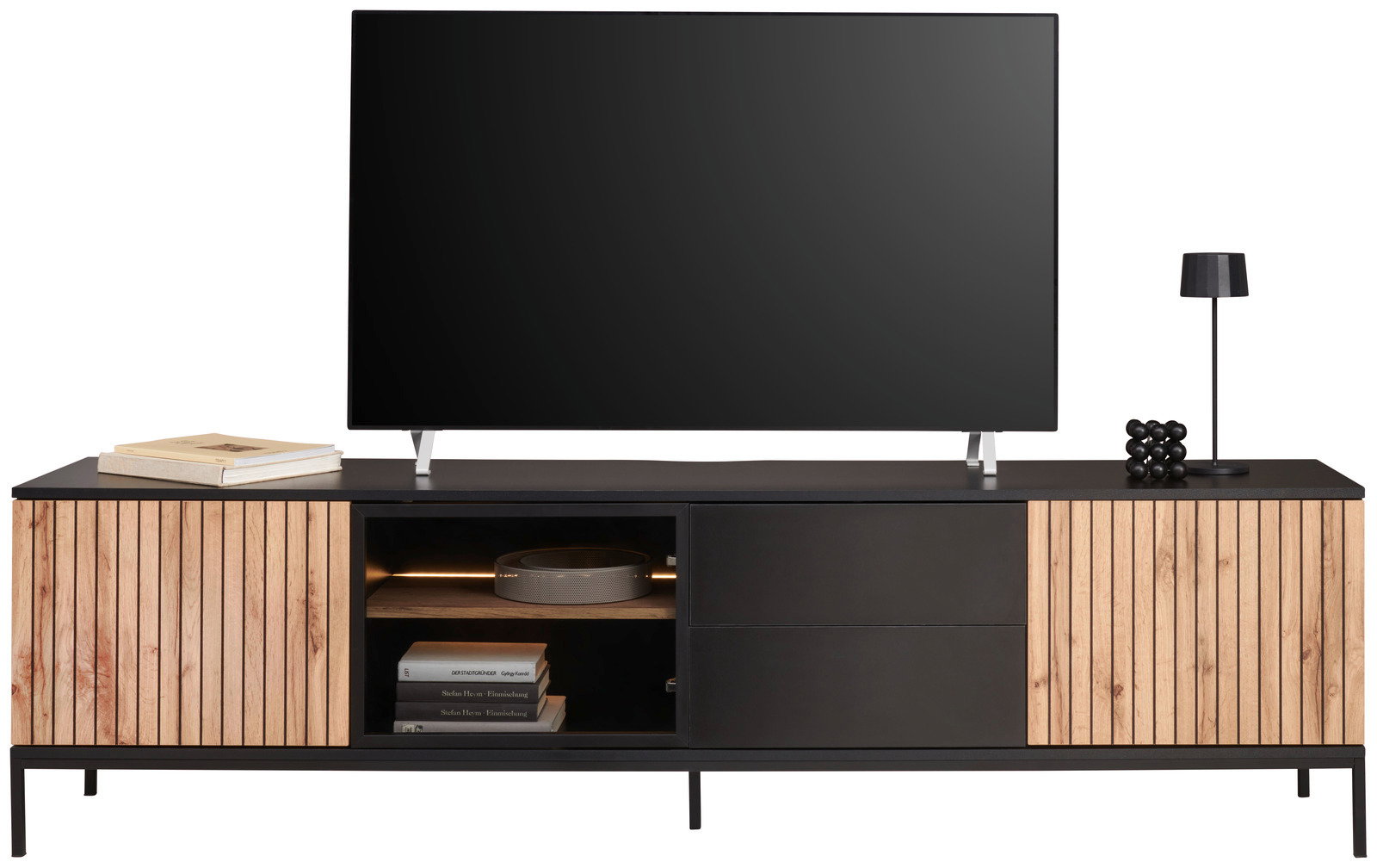 Frontansicht eines modernen XL-TV-Lowboards mit Holz- und Metallelementen, dekoriert mit Büchern, einer Lampe und einem Fernseher.
