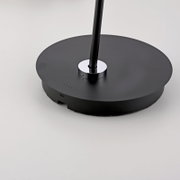 Close-up van de voet van een zwarte staande lamp op accu met USB-aansluiting en laadindicator.