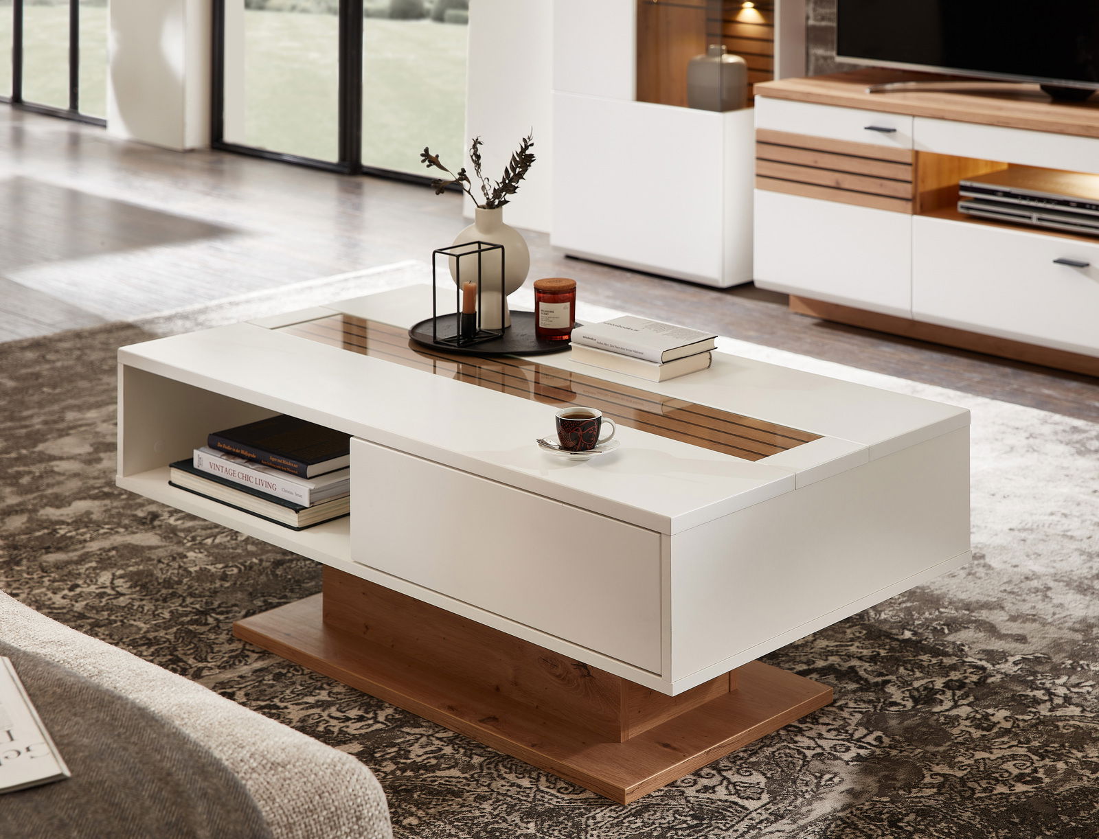 Zurbrüggen Couchtisch FRESNO Moderner Couchtisch in Weiß mit Holzdetails, dekoriert mit Büchern und einer Tasse, seitliche Perspektive