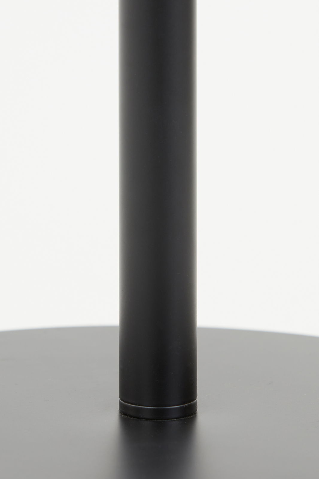 Nahaufnahme des schwarzen Standfußes einer Stehleuchte, von der Seite betrachtet.