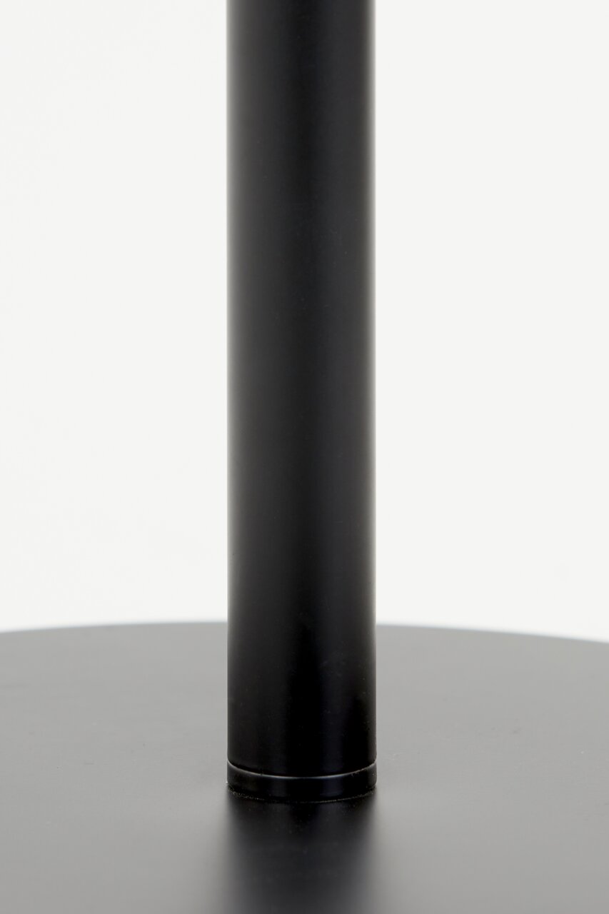 Close-up van de zwarte voet van een staande lamp, gezien vanaf de zijkant.