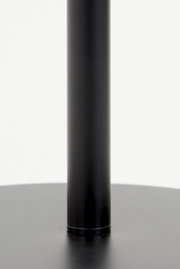 Close-up van de zwarte voet van een staande lamp, gezien vanaf de zijkant.