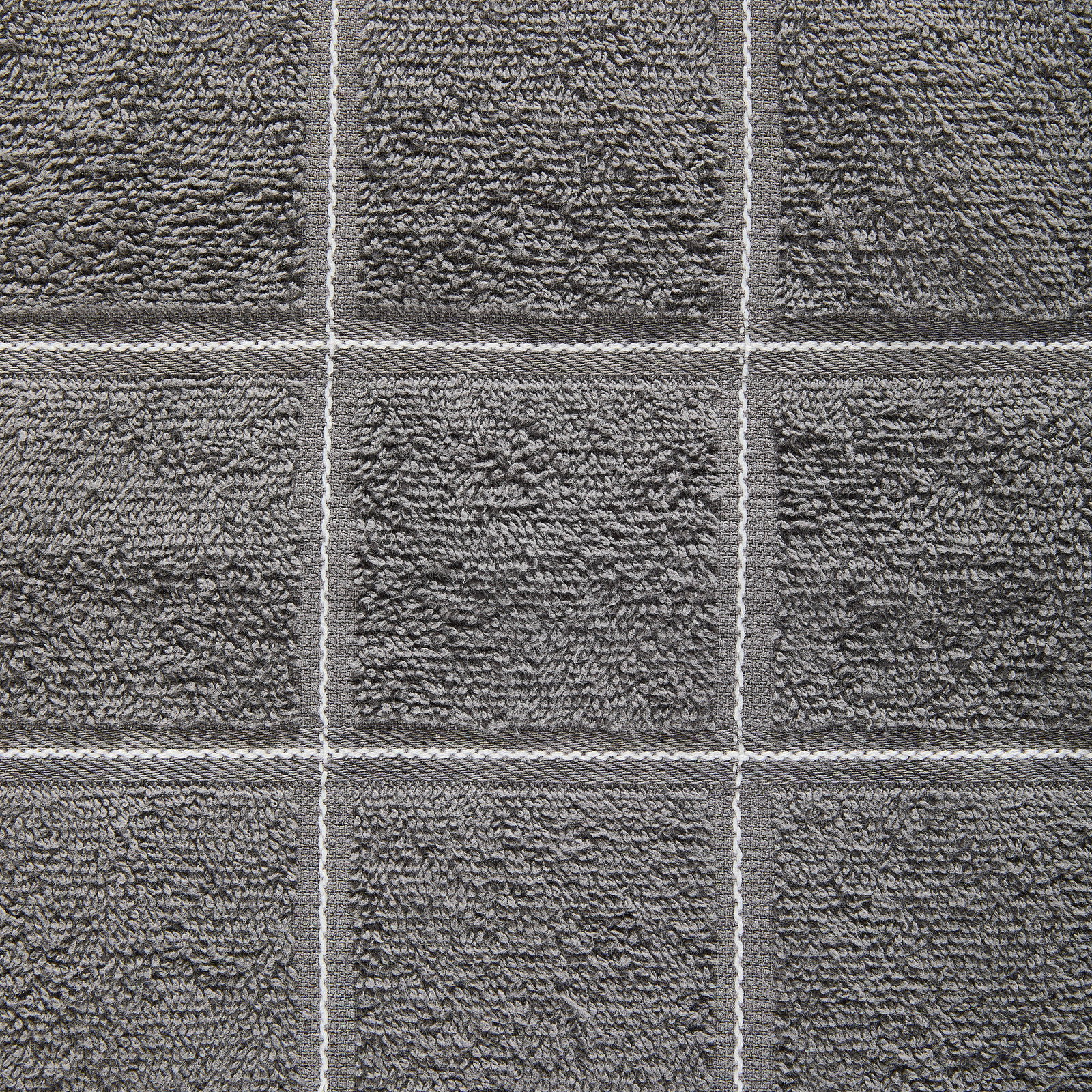 Nahaufnahme eines grauen Frottierhandtuchs mit quadratischem Muster.