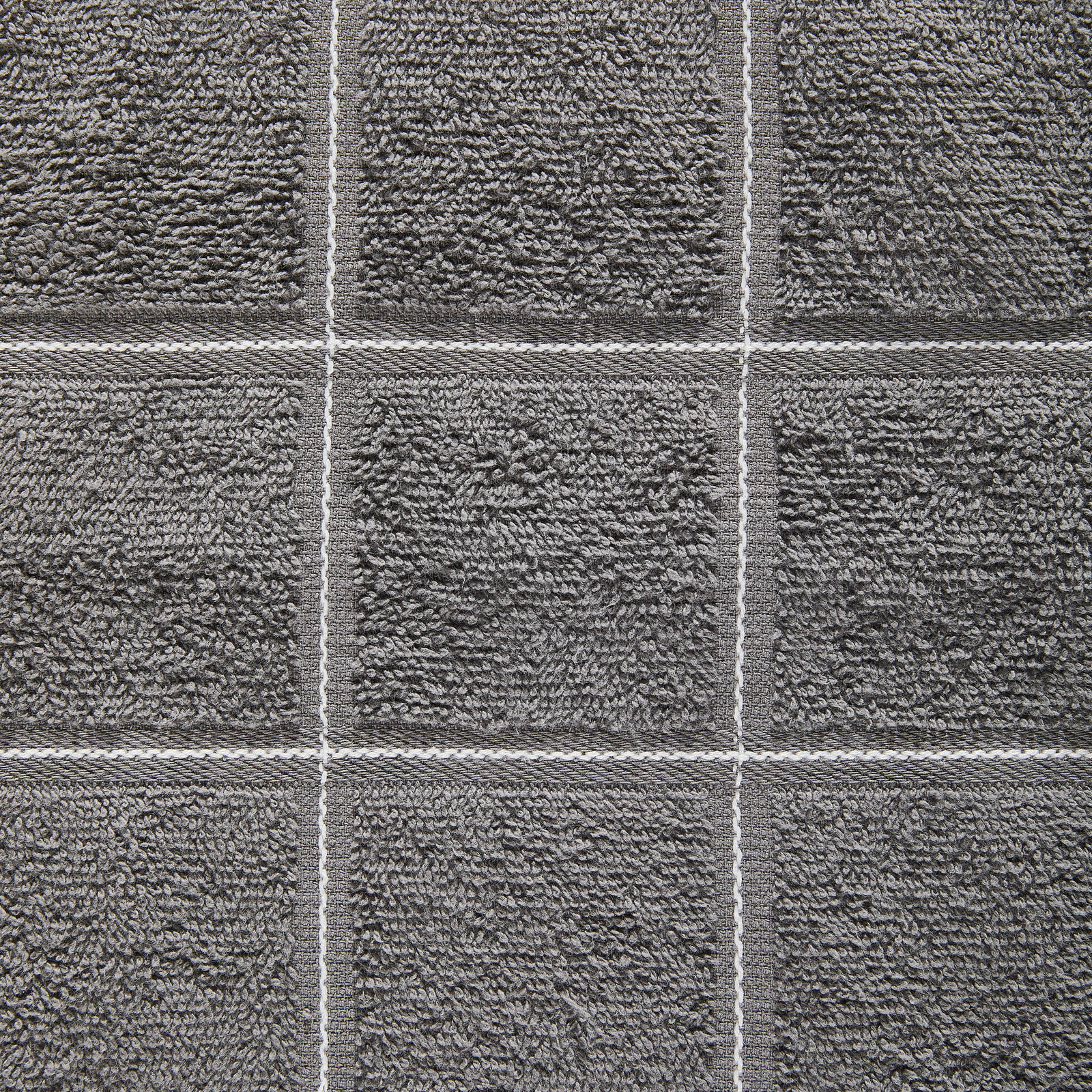 Nahaufnahme eines grauen Frottierhandtuchs mit quadratischem Muster.