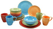 Buntes 16-teiliges Kombiservice mit Tellern, Schalen und Tassen in verschiedenen Farben, aus einer leicht erhöhten Perspektive fotografiert.