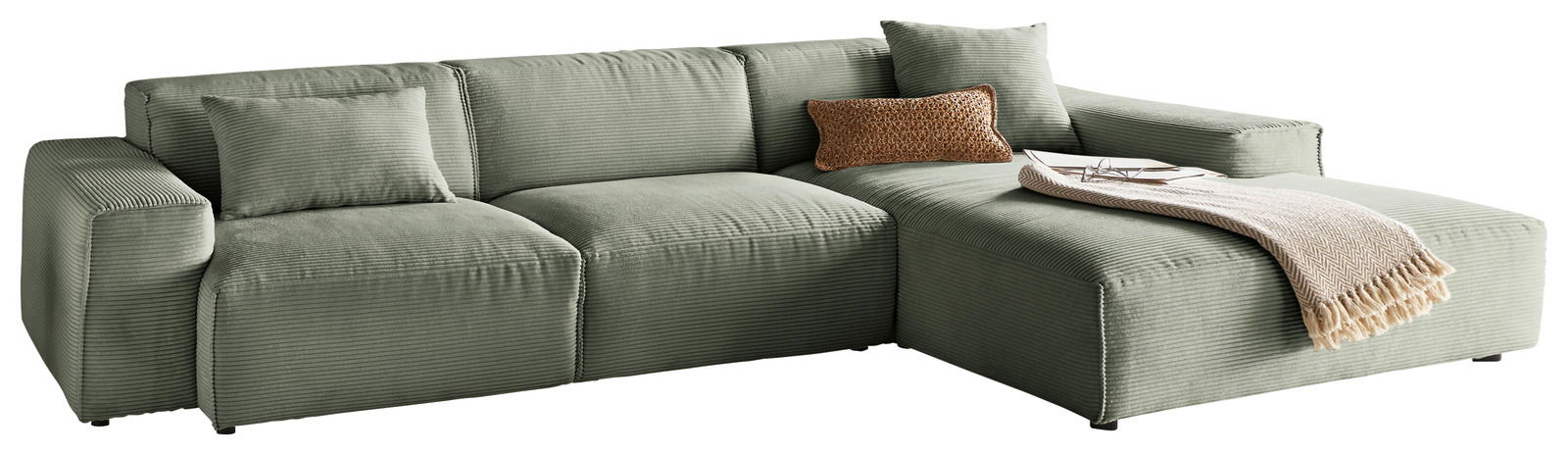 Grünes Ecksofa mit Ottomane rechts, aus weichem Stoff, dekoriert mit Kissen und Decke, Perspektive von vorne.