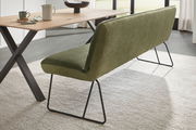 Grüne Polsterbank mit Metallbeinen, seitliche Perspektive neben einem Holztisch.