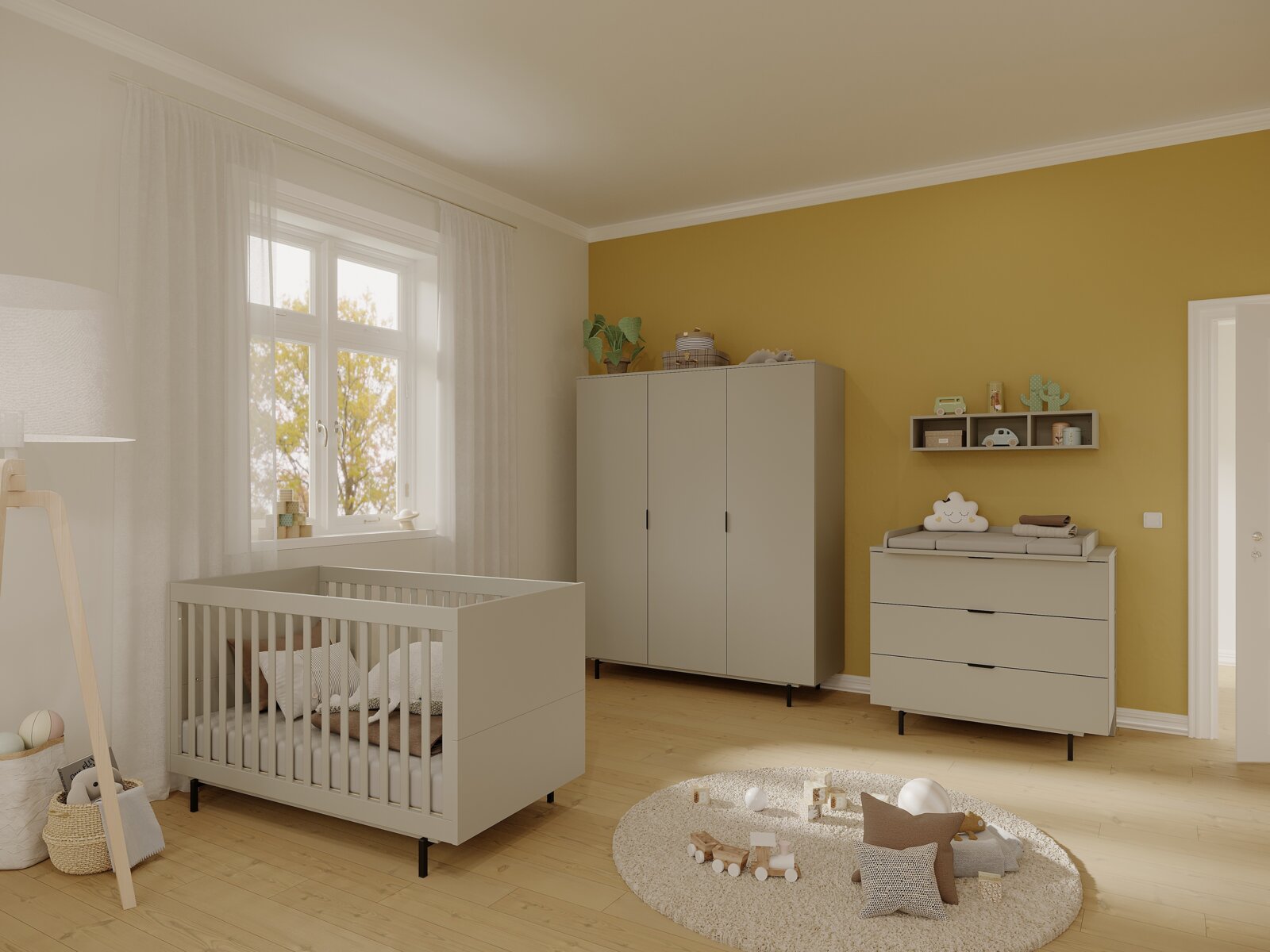 Kinderzimmer mit einem modernen, grauen Kinderbett in der linken Bildhälfte, umgeben von einem Kleiderschrank und einer Wickelkommode, aus der Perspektive eines Betrachters, der den Raum betritt.