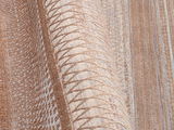 Nahaufnahme eines Designer-Teppichs mit geometrischem Muster in Beige- und Brauntönen, seitliche Perspektive