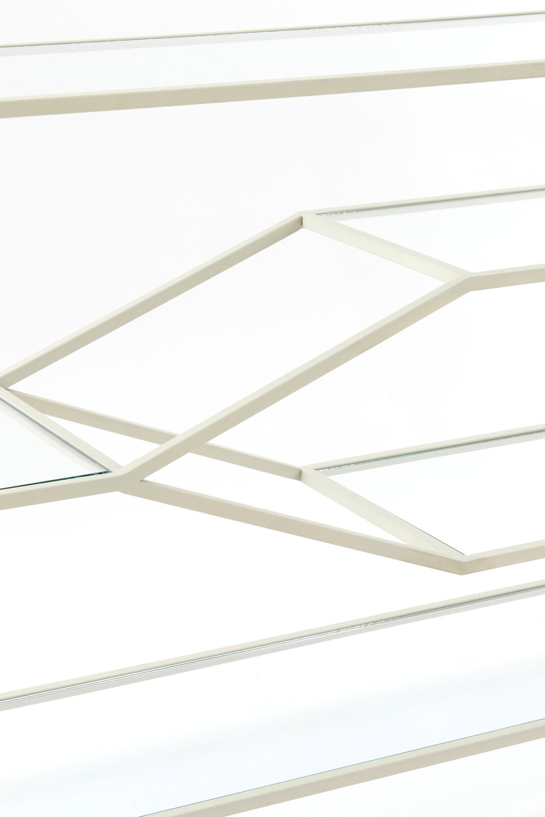 Nahaufnahme eines Konsolentisches mit geometrischem Metallrahmen und Glasplatten, seitliche Perspektive