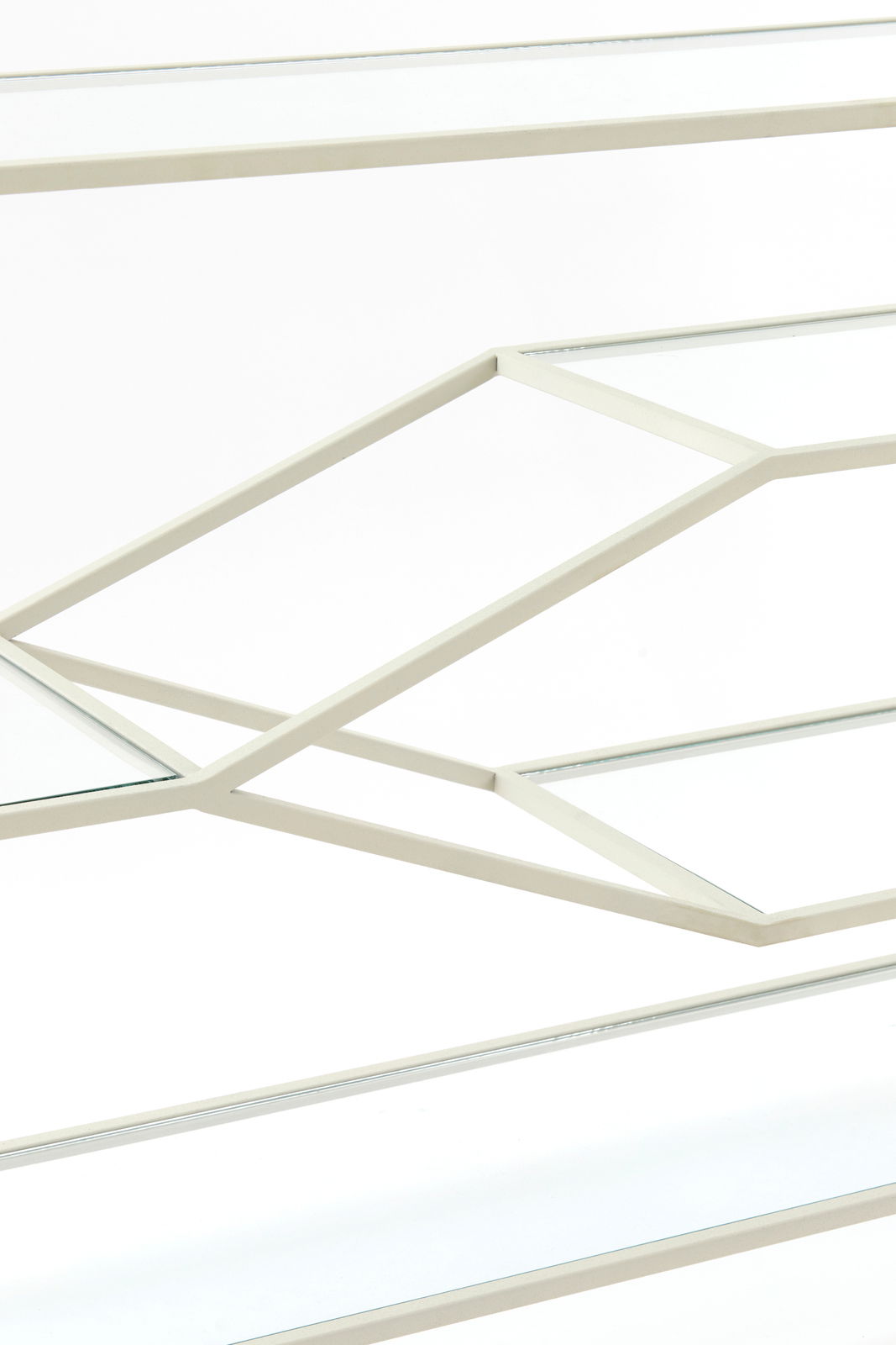 Nahaufnahme eines Konsolentisches mit geometrischem Metallrahmen und Glasplatten, seitliche Perspektive