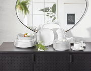 Kombiservice Lido Black eckig auf einem schwarzen Schrank, mit einem Spiegel im Hintergrund, der das Geschirr aus einer frontalen Perspektive zeigt.