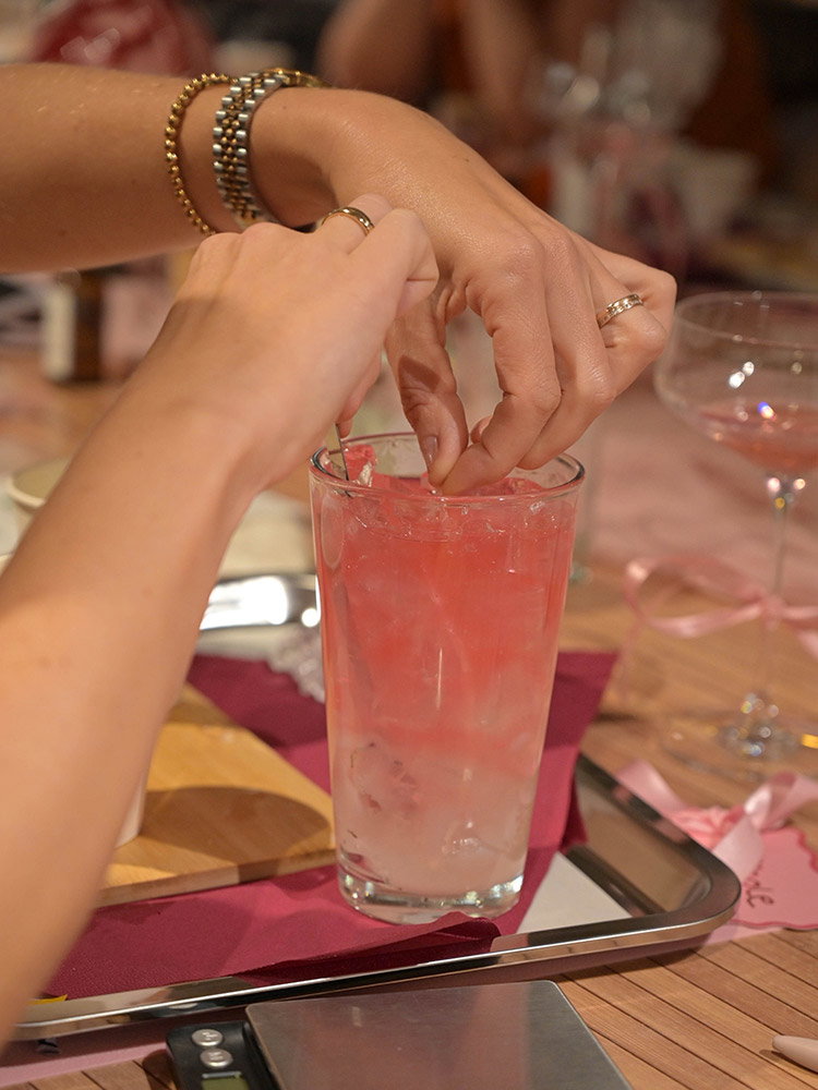 Een deelneemster maakt een roze kaars in een glas tijdens een creatieve Get Together-workshop.