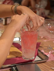 Een deelneemster maakt een roze kaars in een glas tijdens een creatieve Get Together-workshop.