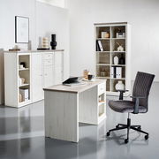 Moderner Schreibtisch in heller Holzoptik, umgeben von passenden Regalen und einem Bürostuhl, aus der Perspektive eines Betrachters im Raum.