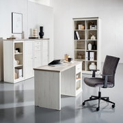 Een modern bureau in een lichte houtlook, omringd door bijpassende planken en een bureaustoel, gezien vanuit het perspectief van iemand die in de kamer staat.