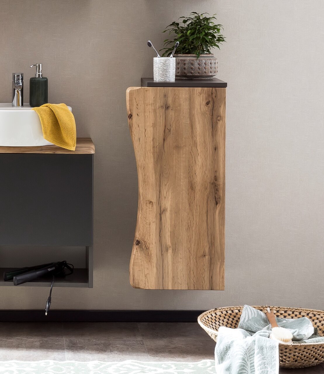 Moderne houten onderkast met natuurlijke nerf, zijaanzicht, versierd met een plant en een tandenborstelhouder.
