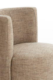 Nahaufnahme eines Sessels mit beigem Stoffbezug, seitliche Perspektive