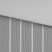Detailaufnahme aus schräger Draufsicht: grauer Stoff mit feinen, vertikalen Streifen und sichtbarer Kante/Naht vor hellem Hintergrund