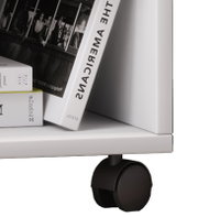 Nahaufnahme eines weißen Möbelwagens/Regalbodens mit schwarzer Doppelrolle, seitliche Perspektive von unten; darauf liegen Bücher und eine kleine Box