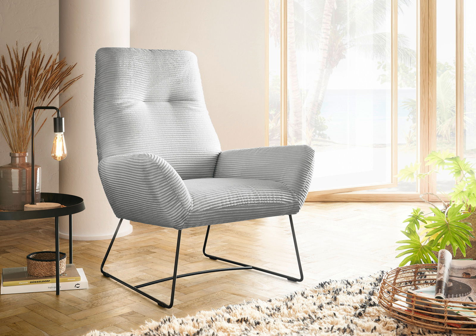 Lounge Handmade Sessel LH-BEN Moderner grauer Sessel mit geripptem Stoffbezug, seitliche Perspektive, in einem hellen Raum mit großen Fenstern und Holzboden.