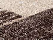 Nahaufnahme eines strukturierten Teppichs in Creme- und Brauntönen, perspektivisch von der Seite aufgenommen.