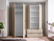 Beiger Kleiderschrank mit geöffneten Drehtüren, Innenfächern, Kleiderstange und zwei Schubladen, frontale Ansicht im Schlafzimmer