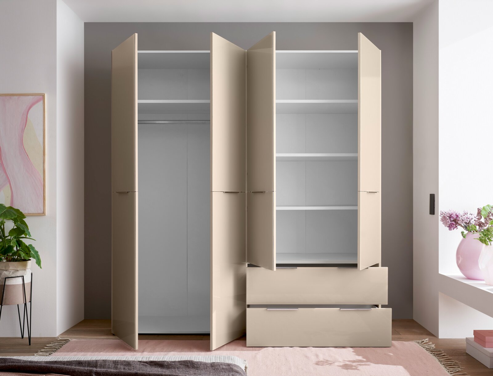 Beiger Kleiderschrank mit geöffneten Drehtüren, Innenfächern, Kleiderstange und zwei Schubladen, frontale Ansicht im Schlafzimmer