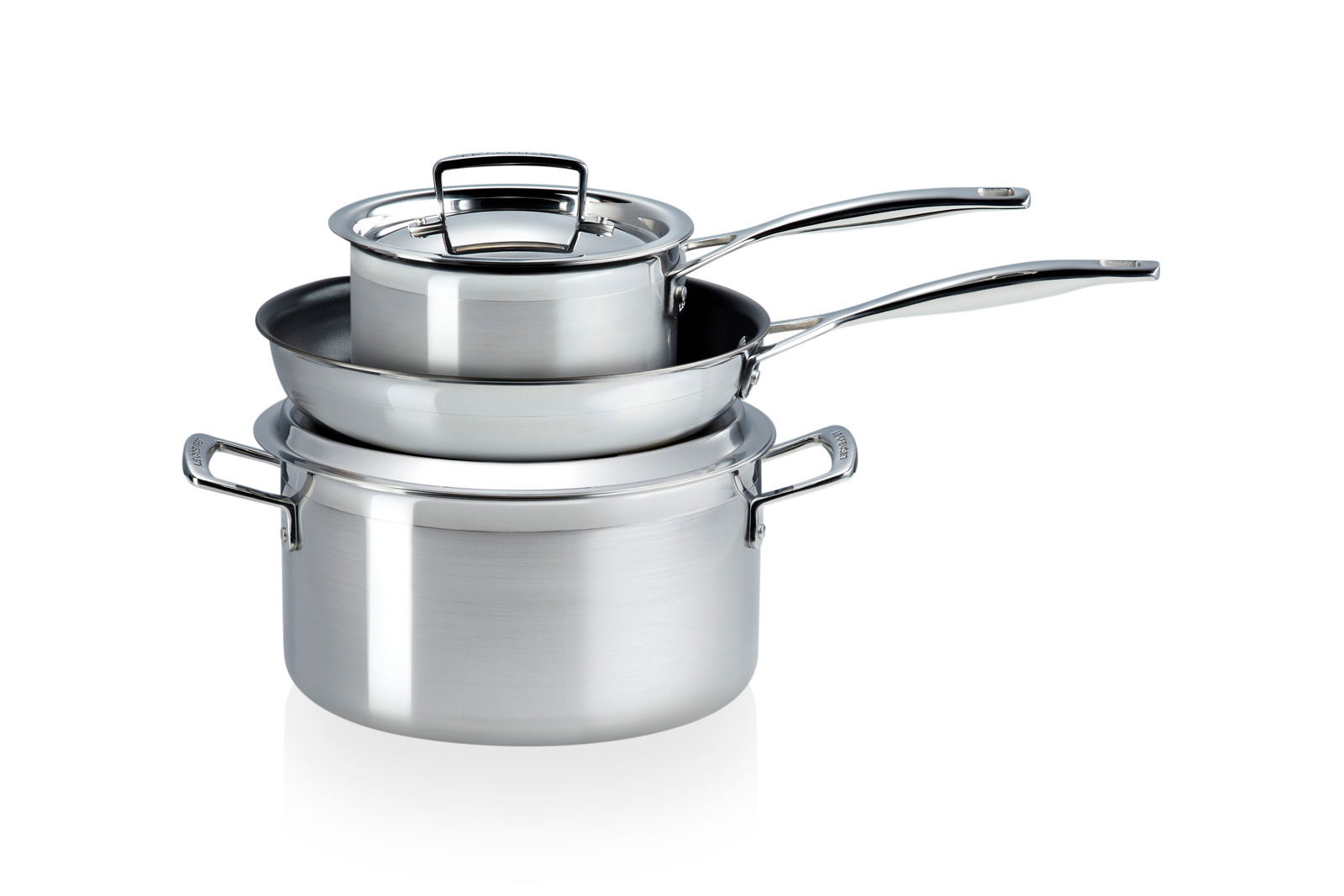 Dreiteiliges Topfset aus Edelstahl, bestehend aus einem großen Topf, einer Pfanne und einem kleineren Topf mit Deckel, gestapelt und aus einer leicht erhöhten Perspektive fotografiert.