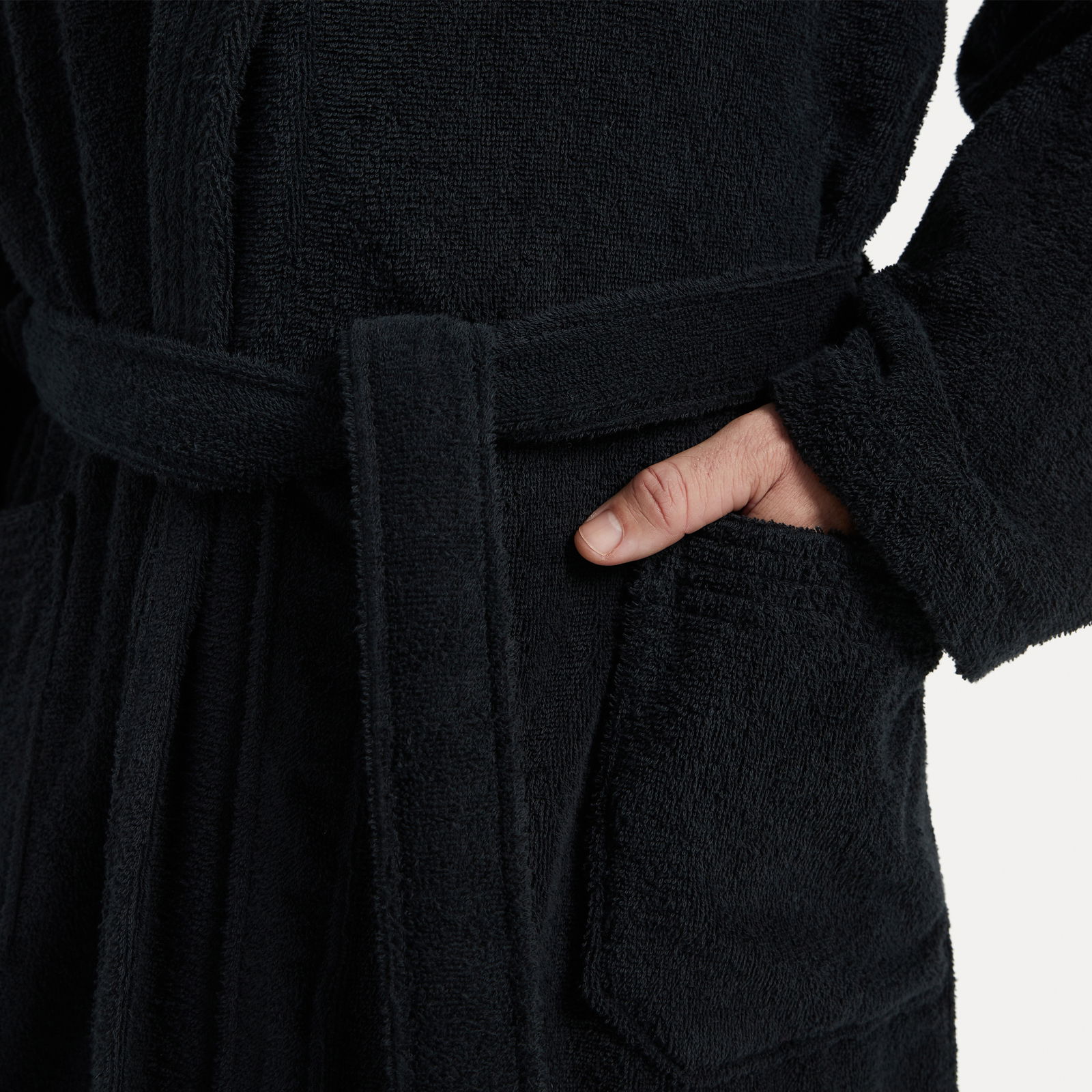 MÖVE Bademantel Schalkragen XS HOMEWEAR BASIC Nahaufnahme eines schwarzen Bademantels mit Schalkragen, Gürtel und Tasche, Hand in der Tasche.