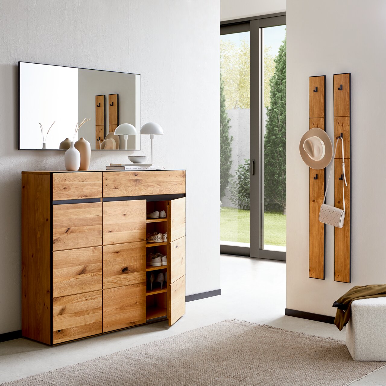 Linea Natura XL-Spiegel KELIO MAX Moderner Eingangsbereich mit einem XL-Spiegel an der Wand, einem großen Schuhschrank aus Holz mit offenen und geschlossenen Fächern, und zwei Garderobenpaneelen mit Haken, seitliche Perspektive.