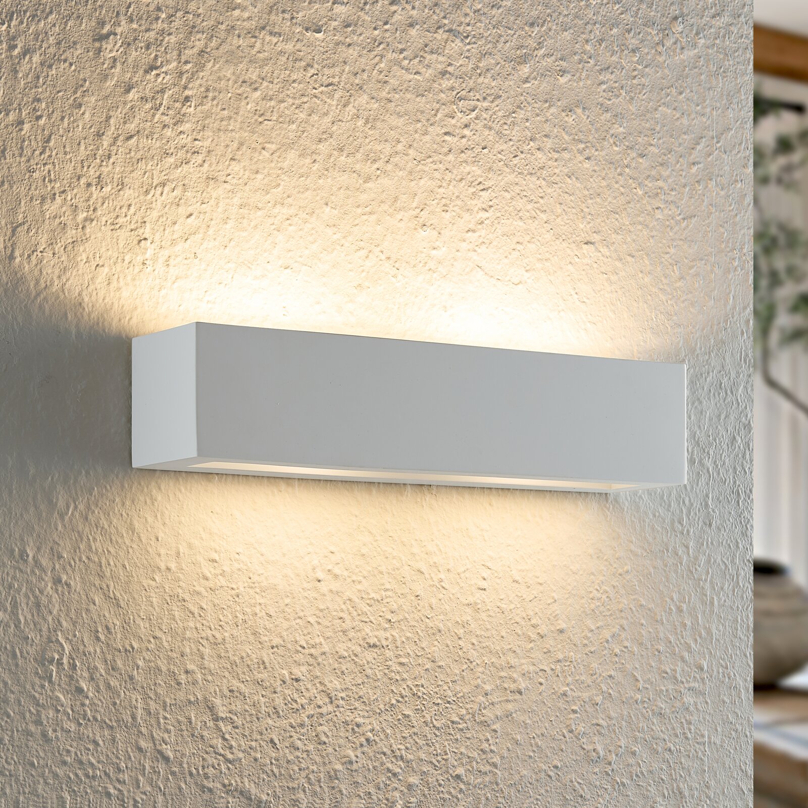 Moderne weiße Wandleuchte mit rechteckigem Design, die warmes Licht nach oben und unten an die Wand abstrahlt, seitliche Perspektive