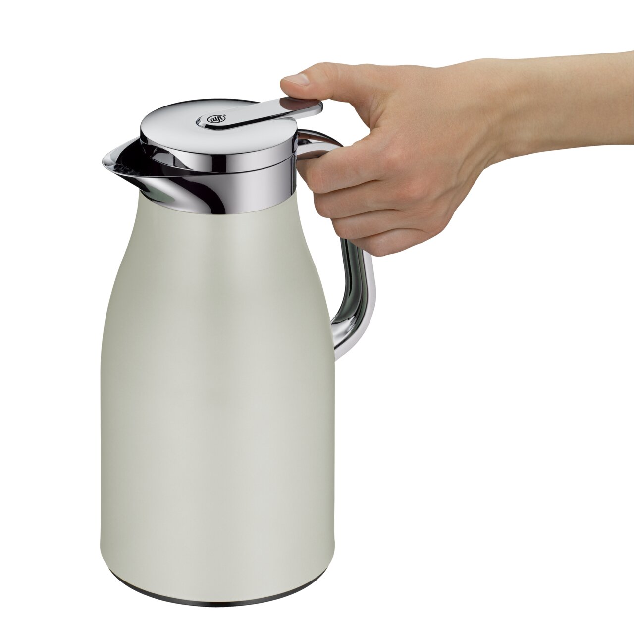 Silberne Thermoskanne mit glänzendem Deckel und Griff, von der Seite betrachtet, mit einer Hand am Griff.