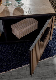 Nahaufnahme eines Couchtisches mit geöffneter Tür, die einen Stauraum mit einer dekorativen Box zeigt. Die Tischoberfläche ist aus Holz mit Glasdekorationen. Perspektive von oben.