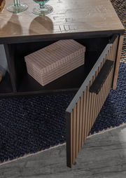 Nahaufnahme eines Couchtisches mit geöffneter Tür, die einen Stauraum mit einer dekorativen Box zeigt. Die Tischoberfläche ist aus Holz mit Glasdekorationen. Perspektive von oben.