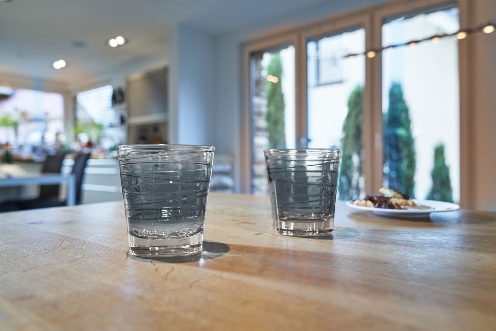 Leonardo Trinkglas VARIO Zwei Trinkgläser Vario Anthrazit 250ml auf einem Holztisch in einer modernen Küche, seitliche Perspektive.